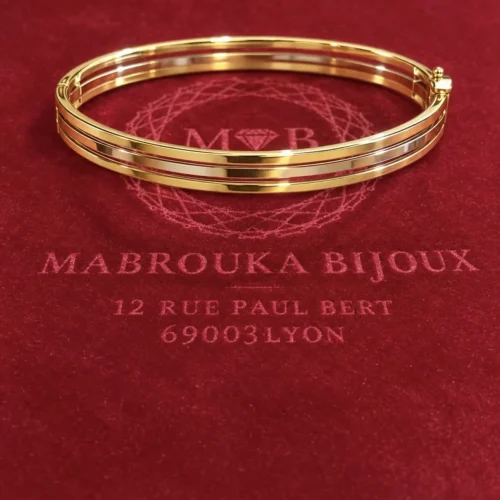 Bracelet jonc Katarina trois ors 18 carats sur fond bordeaux Mabrouka Bijoux